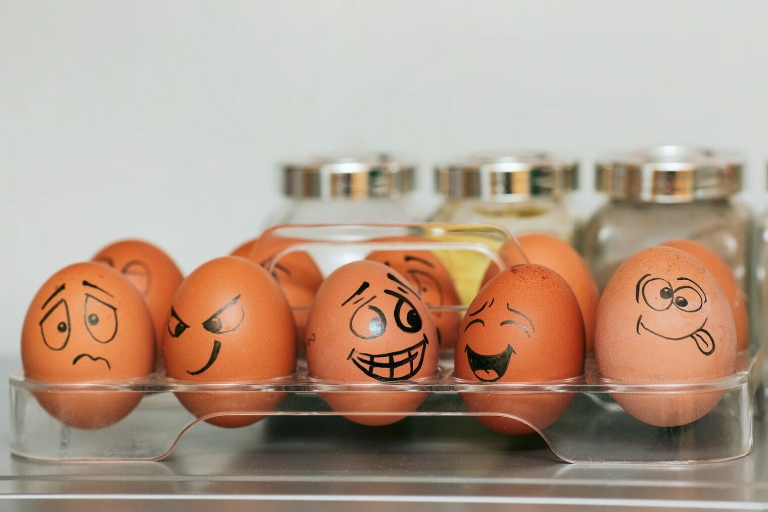 A tray of eggs with faces drawn on them used in parenting behavior therapy for healthcare equity.