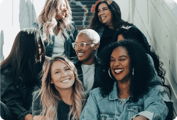 A group of women smiling together, promoting mental health and family wellness.